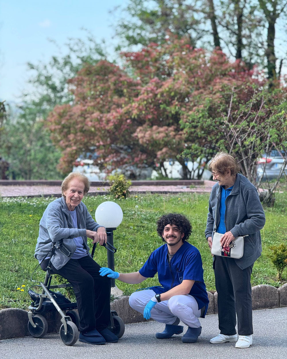 Due ospiti di Villa Salmata sorridono vicine, guancia a guancia, nel giardino della struttura