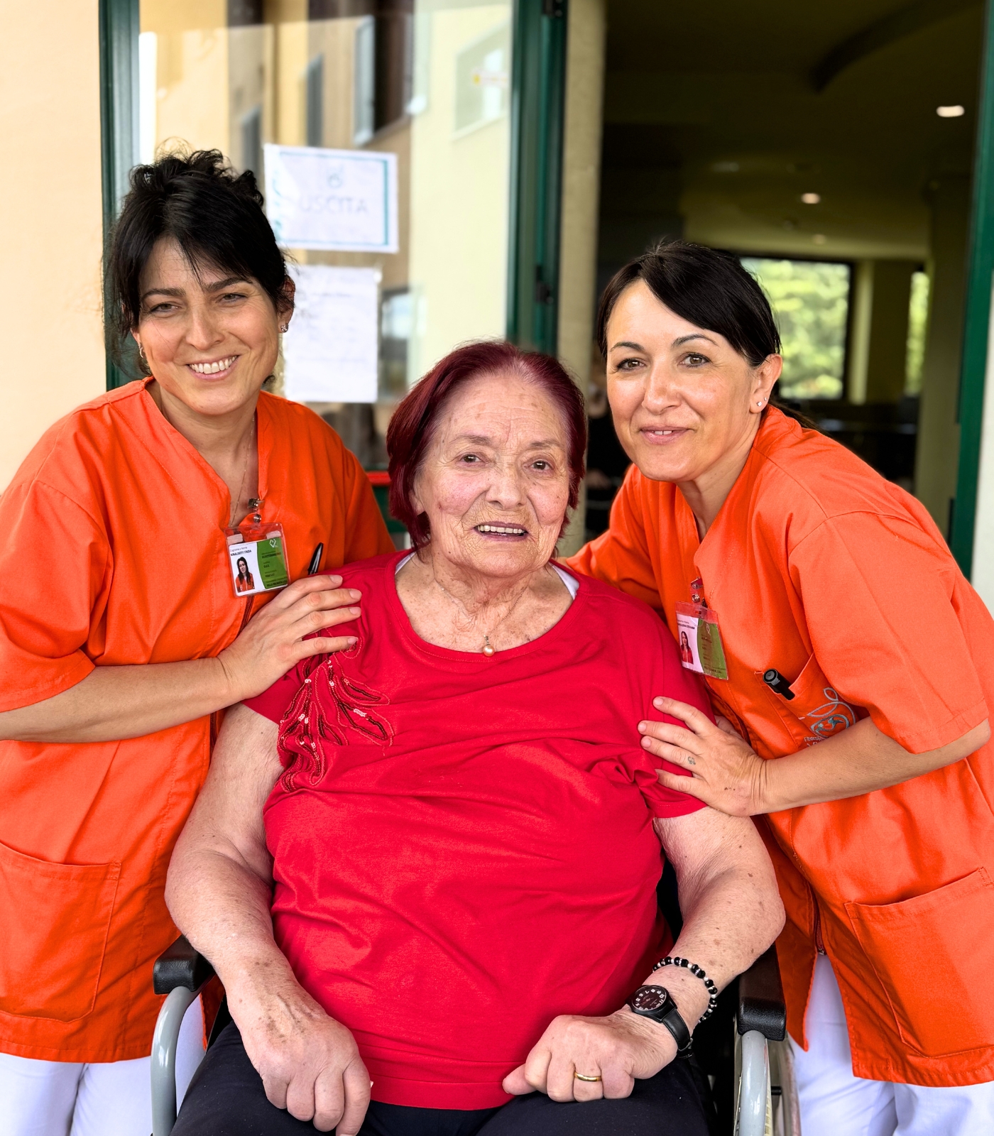 Due operatrici di Villa Salmata sorridono insieme a un'ospite della Residenza Protetta